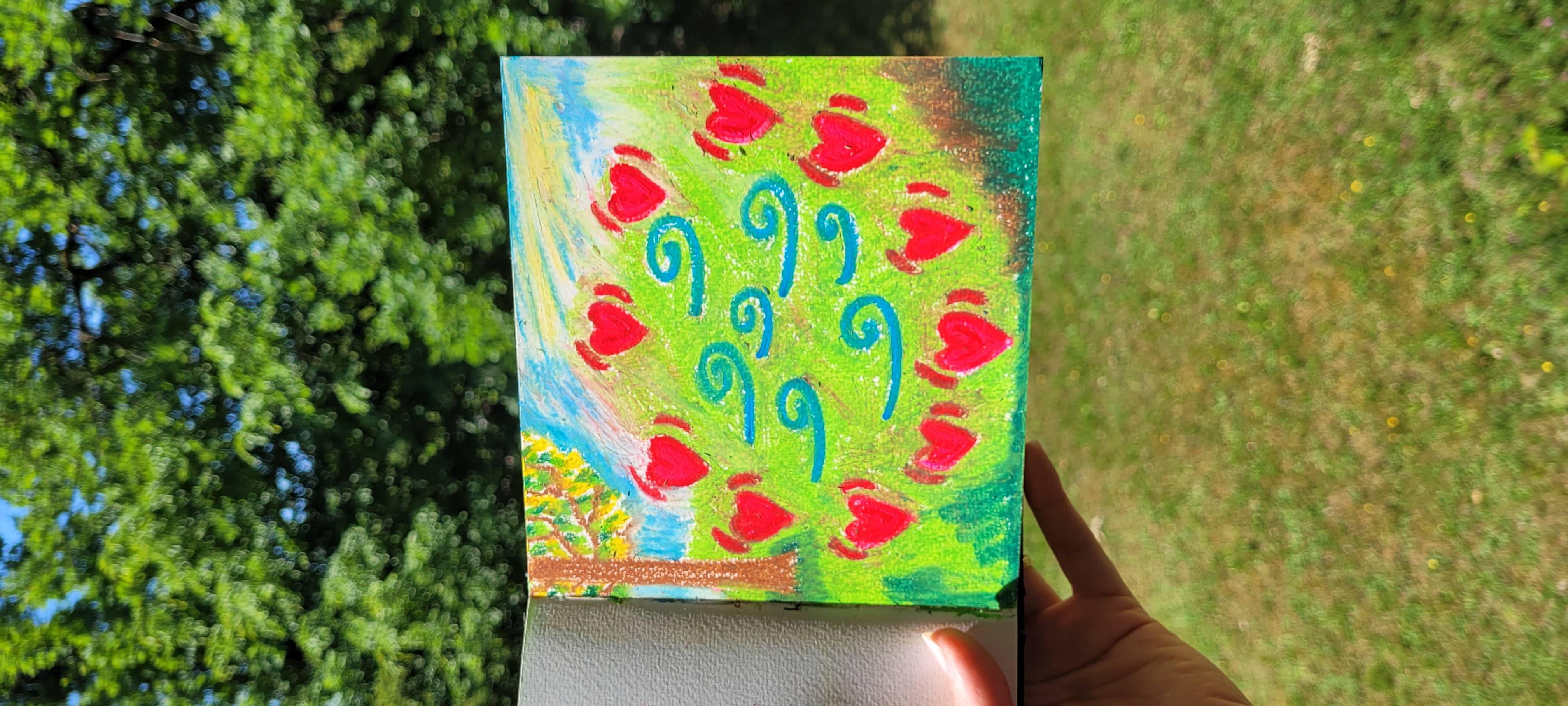 Painting of red hearts and blue breath-swirls on green, held outdoors — the Breathing Heart Circle made visible.